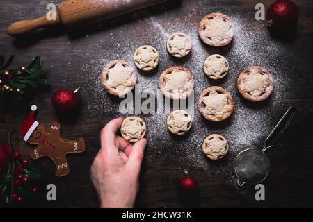 A home baking concept of traditional Christmas mince pies arranged in the shape of a Christmas Tree and covered in icing sugar Stock Photo