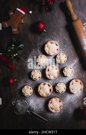 A home baking concept of traditional Christmas mince pies arranged in the shape of a Christmas Tree and covered in icing sugar Stock Photo