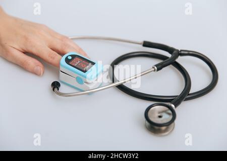 Stethoscope, pulse oximeter and thermometer gun on white background. Treatment of cold or flu. Phonendoscope. Infrared isometric thermometer gun to Stock Photo