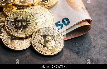 cryptocurrency Bitcoins, on top of Euro banknotes Stock Photo