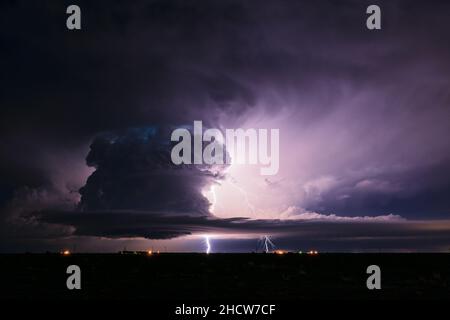 Supercell thunderstorm cumulonimbus cloud illuminated by lightning bolts near Earth, Texas Stock Photo