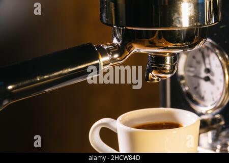 espresso pouring from coffee machine in to a cup. Professional coffee brewing concept image Stock Photo