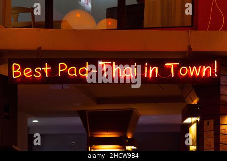 Red neon light above a restaurant saying Best Pad-Thai in town!. Stock Photo