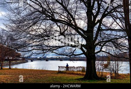 Lone person on a bleak winter day by the river Stock Photo