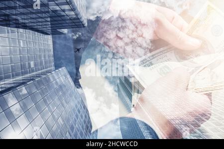 businessman holding and counting money. Skyscraper office building on Double exposure background Stock Photo