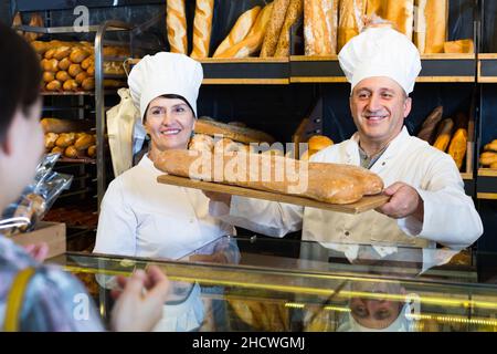 female customer buying bread in bakery. Stock Photo