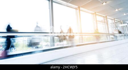 motion blurred commuters walking on a escalator floor Stock Photo