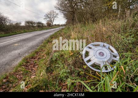 A lost hubcap lying abandoned on a roadside verge in Norfolk. Stock Photo