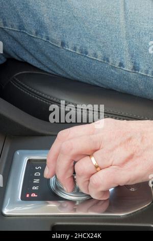 A woman using the gear selector in an automatic car - in this case a Land Rover Discovery. Stock Photo