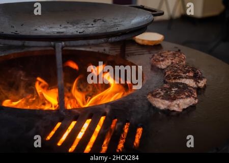 Process of grilling cutlets for burgers on brazier with hot flame Stock Photo