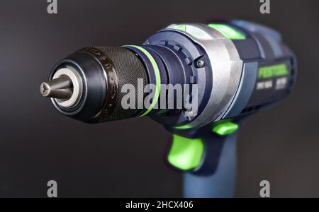 Cordless screwdriver on dark gray blur background. Jaws detail of quick-release chuck. Professional electric tool as screw gun or power drill machine. Stock Photo