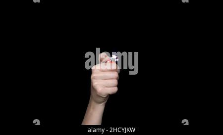 Male hand holding a red lighter, isolated on white background. Hand holding burning gas lighter Stock Photo