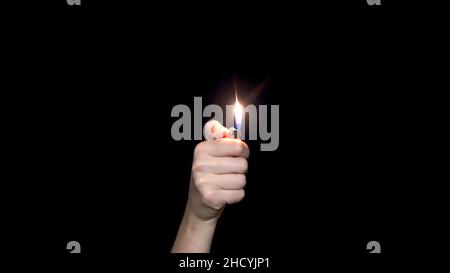 Male hand holding a red lighter, isolated on white background. Hand holding burning gas lighter Stock Photo