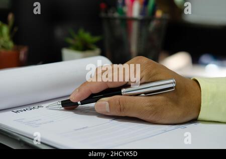 businessman hand holding pen at billing document.Business Finance and Marketing Stock Photo