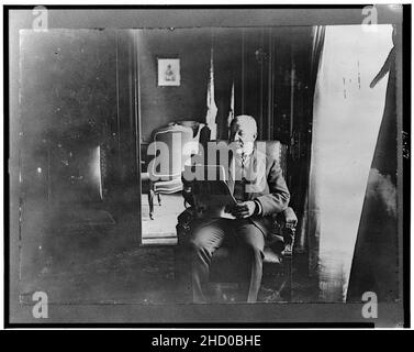 Richard Croker, three-quarter length portrait, seated, reading newspaper, facing left Stock Photo