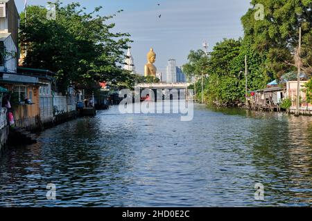 Klong Bangkok Yai, a canal in Thonburi, Bangkok, Thailand, Thonburi once the capital of old Siam; b/g: the giant Buddha of Wat Paknam Phasi Charoen Stock Photo