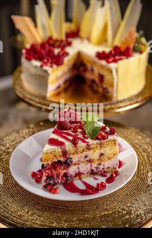 Portion of layered creamy fruit cake served on the white plate Stock Photo