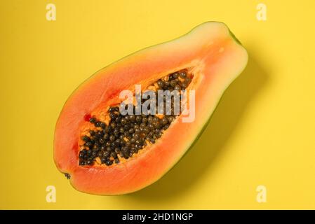 Papaya fruit on a yellow background. Tropical fruit. Half papaya. Stock Photo