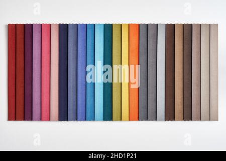 Collection of samples of various colorful fabrics as decorative background in store of sewing materials on white background Stock Photo