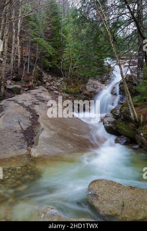 Swiftwater Falls on Dry Brook in Lincoln, New Hampshire on a cloudy spring day during the month of April. This is a trailside waterfall along the Fall Stock Photo