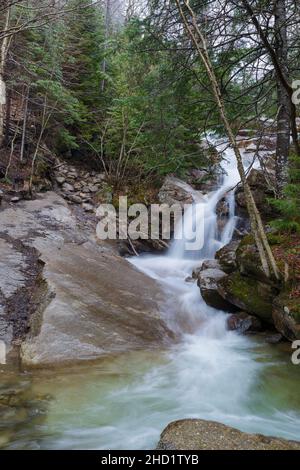 Swiftwater Falls on Dry Brook in Lincoln, New Hampshire on a cloudy spring day during the month of April. This is a trailside waterfall along the Fall Stock Photo