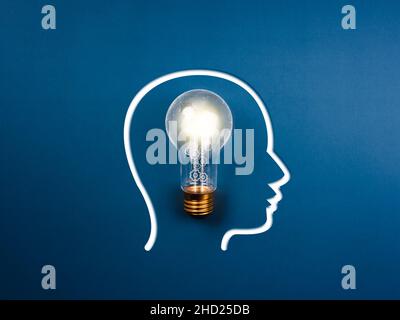Creative idea, innovation, knowledge, and inspiration concept. The human head icon and gears and cogs work inside the light bulb with network connecti Stock Photo