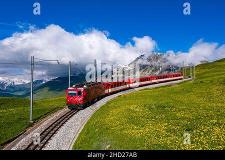 The train Glacier Express, connecting the two major mountain resorts of Zermatt and St. Moritz via Andermatt in the central Swiss Alps. Stock Photo