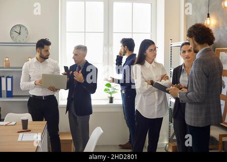 Group of office workers work and solve various issues in a modern coworking center. Stock Photo