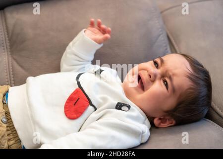 Baby crying with the pain of his first teeth Stock Photo