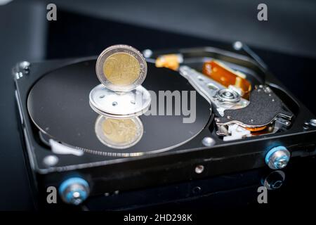 a euro coin is standing on an open hard drive Stock Photo