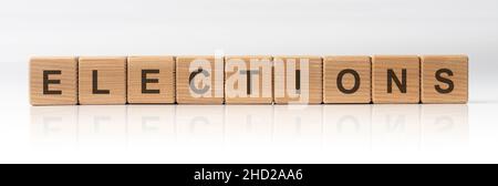 Elections Word Written In Wooden Cubes on white glossy background with reflection Stock Photo