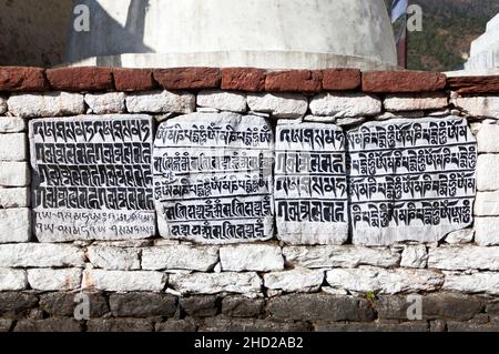 buddhist mani prayer wall on the way to Everest base camp with buddhist tibetan symbols and prayer flags, Khumbu valley, Sagarmatha national park, Nep Stock Photo