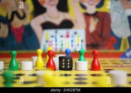 Viersen, Germany - May 9. 2021: View on yellow gameboard with colorful figures and dice  of ravensburger old strategy board game malefiz Stock Photo