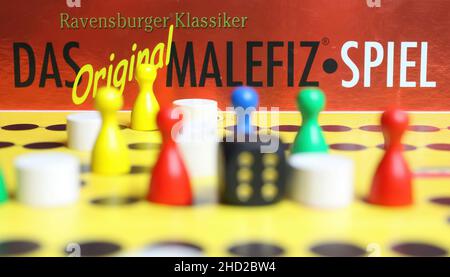 Viersen, Germany - May 9. 2021: View on yellow gameboard with colorful figures and dice  of ravensburger old strategy board game malefiz Stock Photo