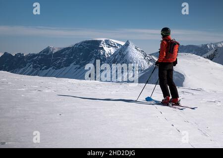 Lapland, Sweden - 18 April, 2019: Single skier in remote location in Swedish Lapland preparing to ski into valley with untracked snow on a bluebird we Stock Photo