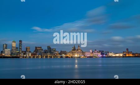 A letterbox crop of the Liverpool skyline over a mirror-like River Mersey on New Years Day in 2022.  The newer buildings on the left of the frame begi Stock Photo
