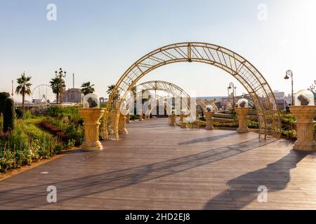 Dubai, UAE, 10.01.21. Global Village amusement park in Dubai, wooden promenade with illuminated arcs, lanterns. Stock Photo