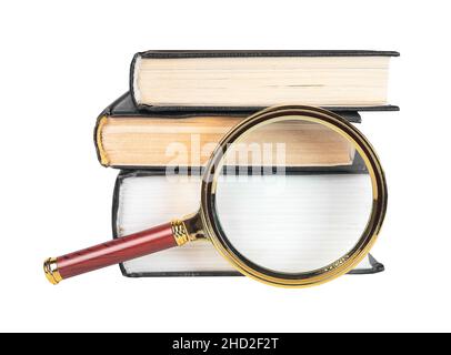 Magnifier over stack of paper books isolated on white. Concept of knowledge, research and studying. Stock Photo