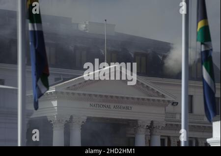 South Africa's national parliament smouldering after a fire broke out in the early hours of 2 January 2022 in central Cape Town Stock Photo