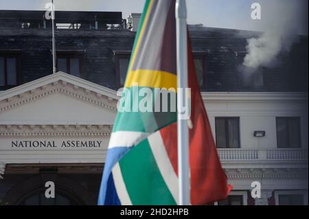 South Africa's national parliament smouldering after a fire broke out in the early hours of 2 January 2022 in central Cape Town Stock Photo