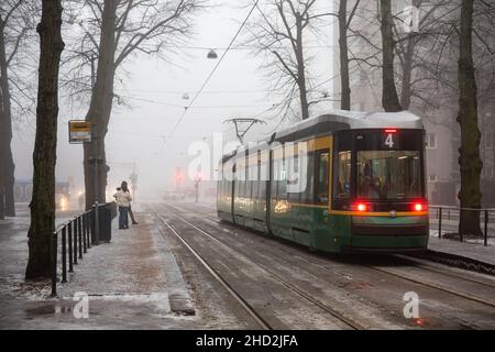 Line 4 tram at Munkkiniemen puistotie tram stop on a foggy winter day  in Munkkiniemi district of Helsinki, Finland Stock Photo