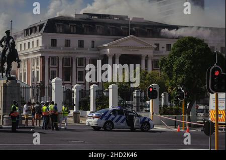 South Africa's national parliament smouldering after a fire broke out in the early hours of 2 January 2022 in central Cape Town Stock Photo
