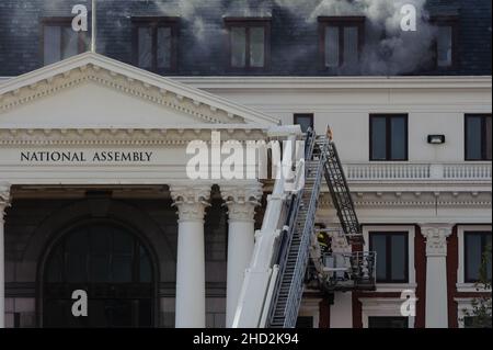 South Africa's national parliament smouldering after a fire broke out in the early hours of 2 January 2022 in central Cape Town Stock Photo