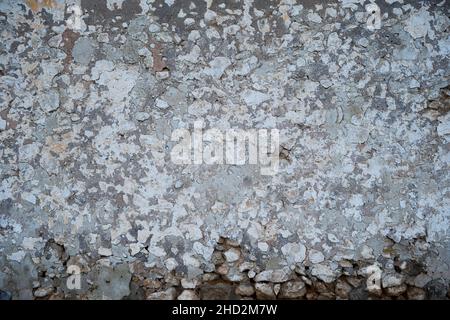 Old traditional limewashed stone wall with peeling plaster, white rustic background or texture Stock Photo