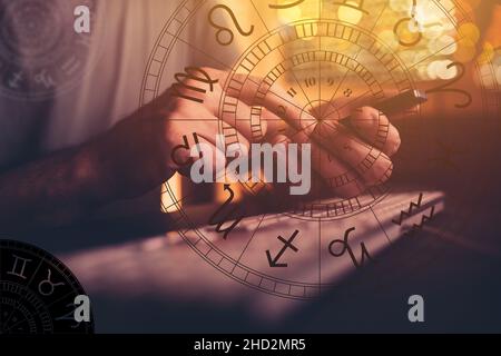 Astrologer using mobile smart phone app and computer to make predictions on future outcome, selective focus Stock Photo