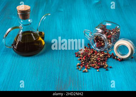 Blue wooden background with a lying pot with multi-colored peppercorns.Copy space. Stock Photo