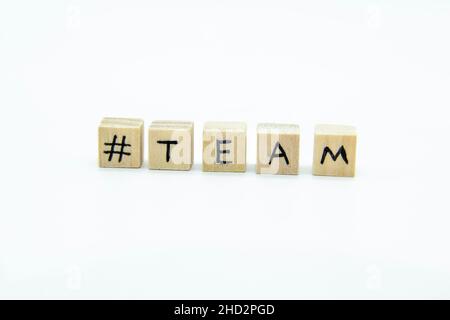 Word TEAM written on the wood cubes on white  background. The concept photo with letters #team Stock Photo