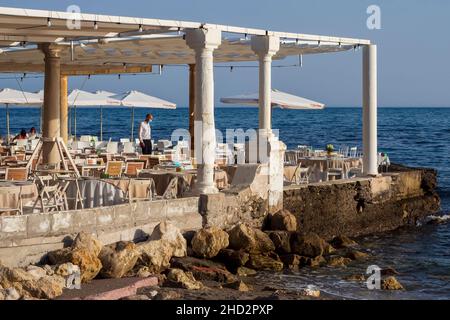 Terrace of a seaside restaurant on the coast of the capital of Malaga on a day of sun and calm sea. Stock Photo