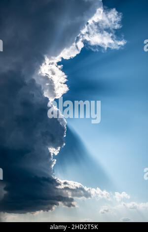 Rays Of Sunlight Shine Through Heavy Grey Clouds Stock Photo