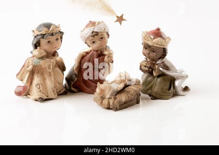 Happy Epiphany Day. Three wise men visit the newborn baby Jesus.  Ceramic figurines isolated on a white background. Copy space. Stock Photo